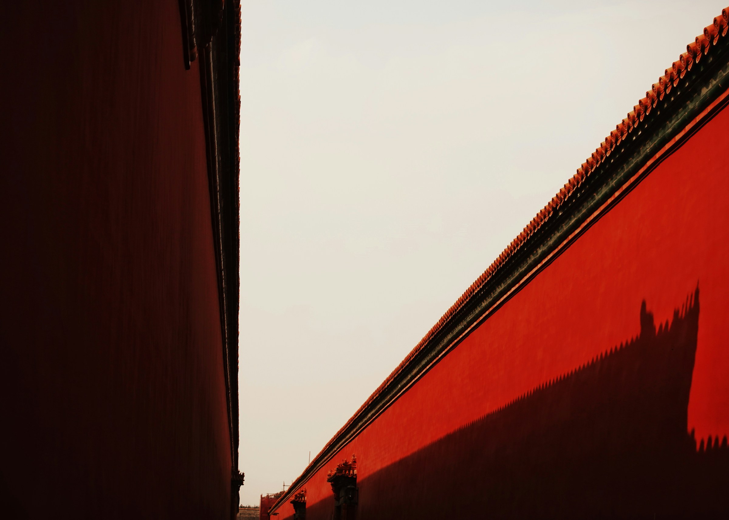 Late light and shadow across red palace walls in Beijing