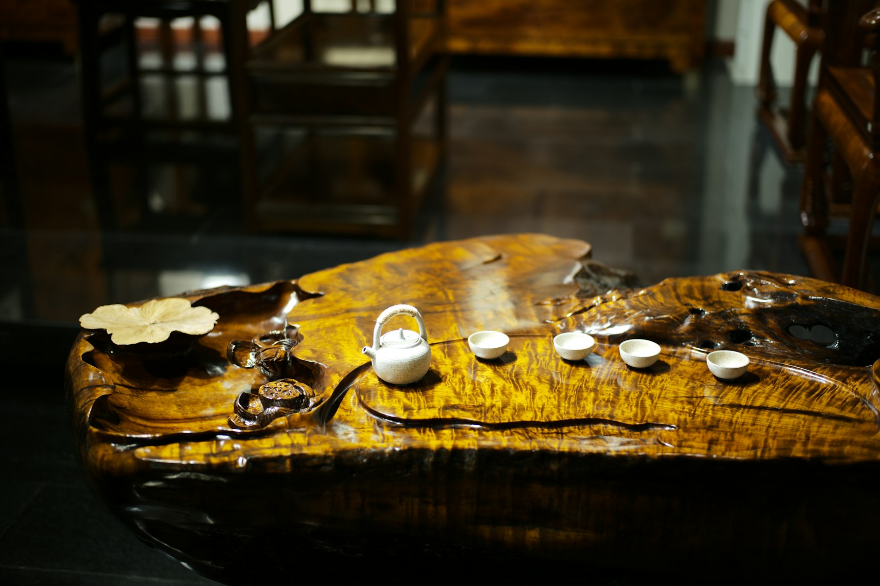 A small tea set on a wooden display with careful composition and detail