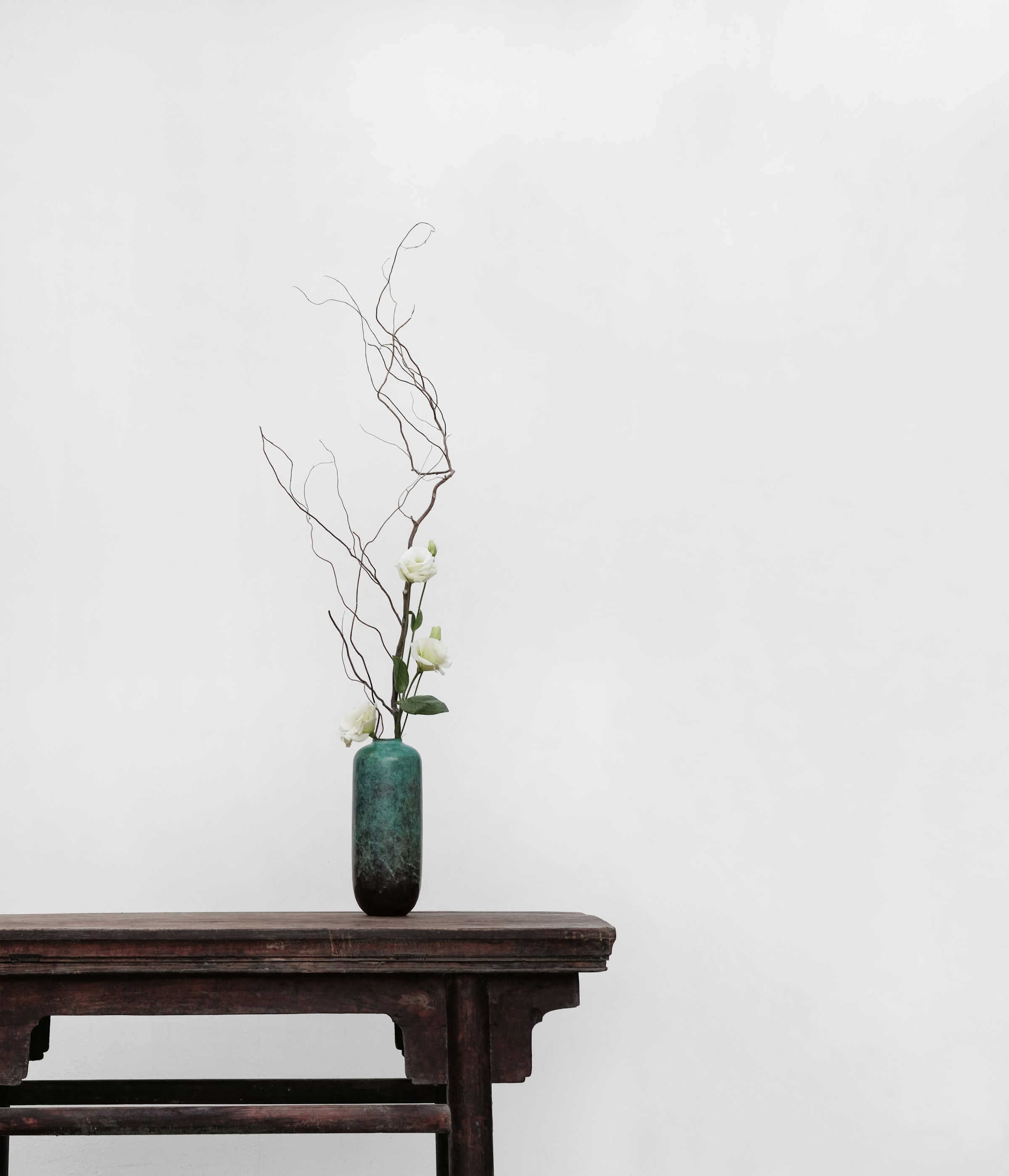 Minimal still life with a vase and branches on a wooden table